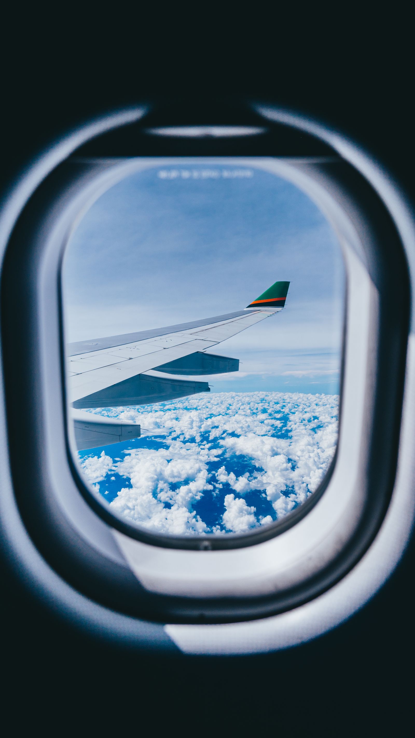 View of an airplane wing above clouds