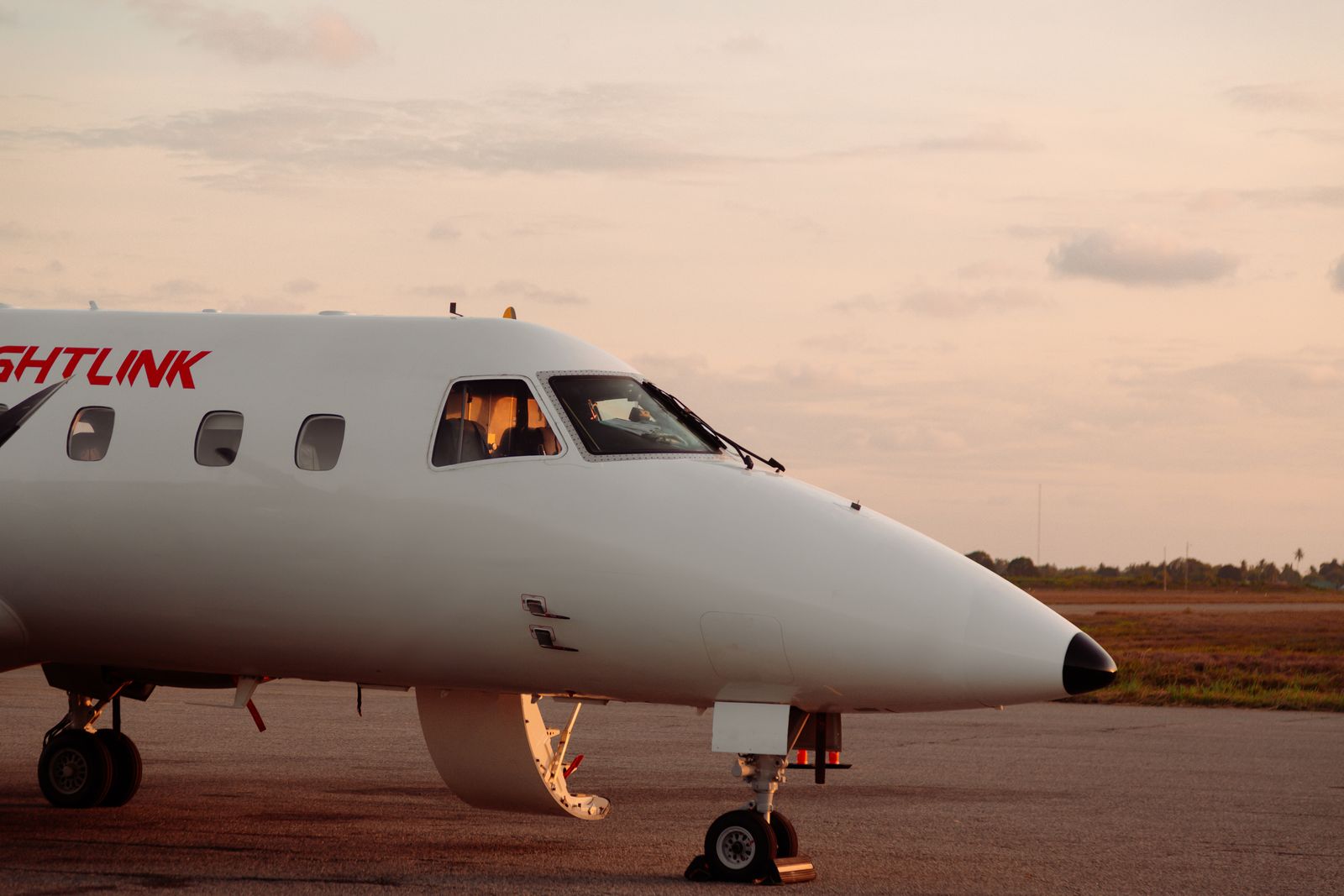 Private jet parked on an airport tarmac at sunset