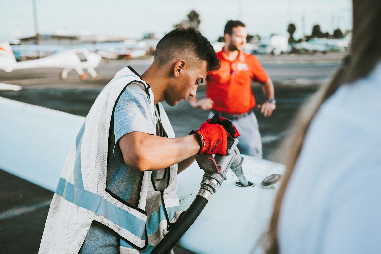 Ground crew member refueling a small private plane on the ramp