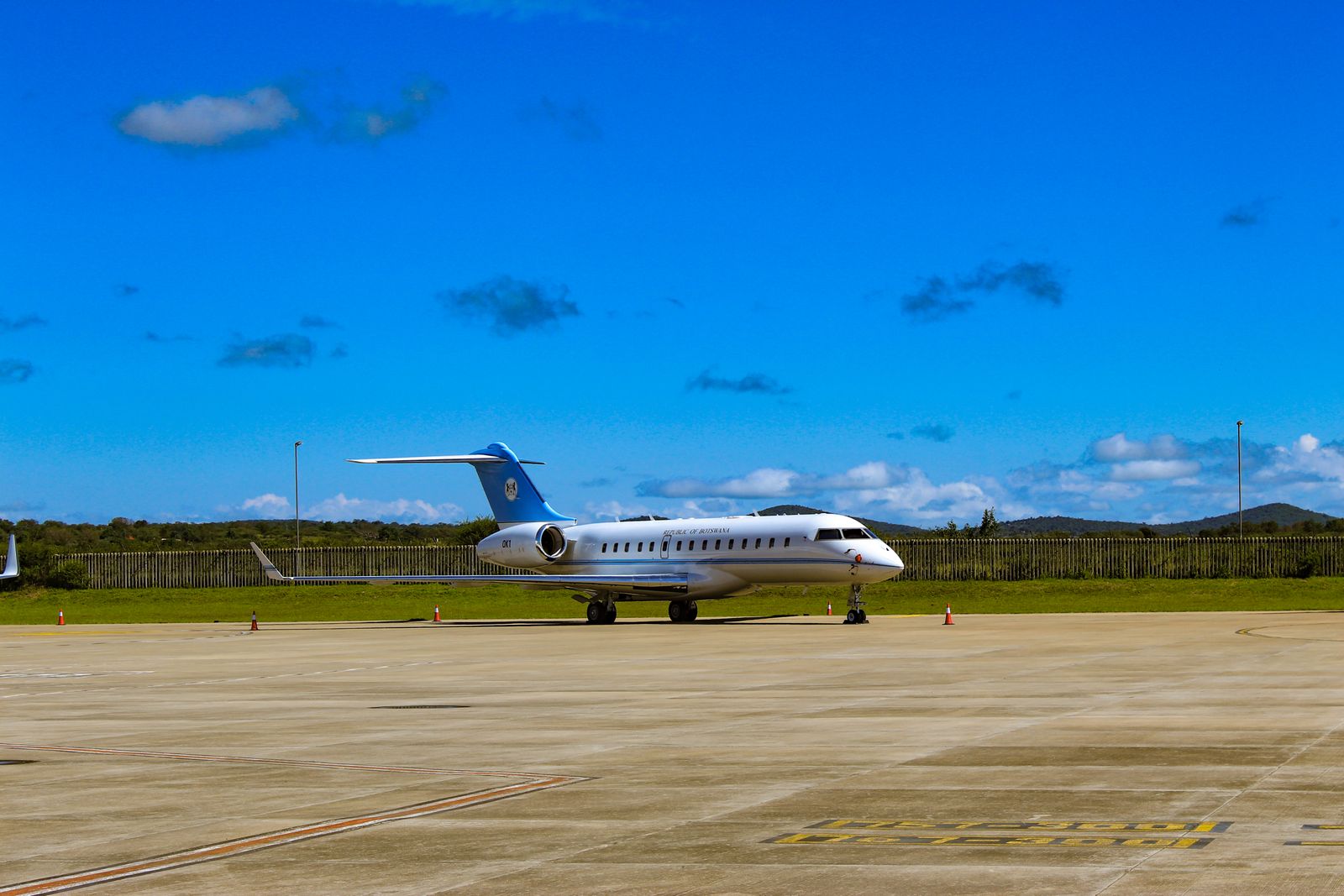 A sleek business jet parked on a tarmac against a deep blue sky.
